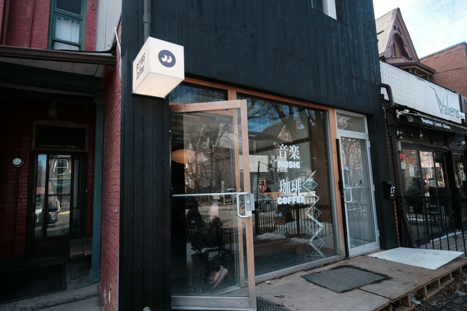 A small coffee shop's storefront with its glass doors open